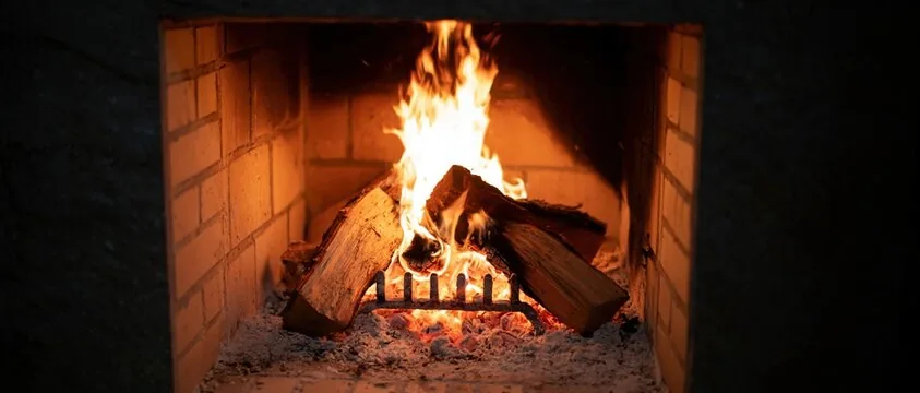 Wood fire burning brightly on a grate in a clean brick firebox